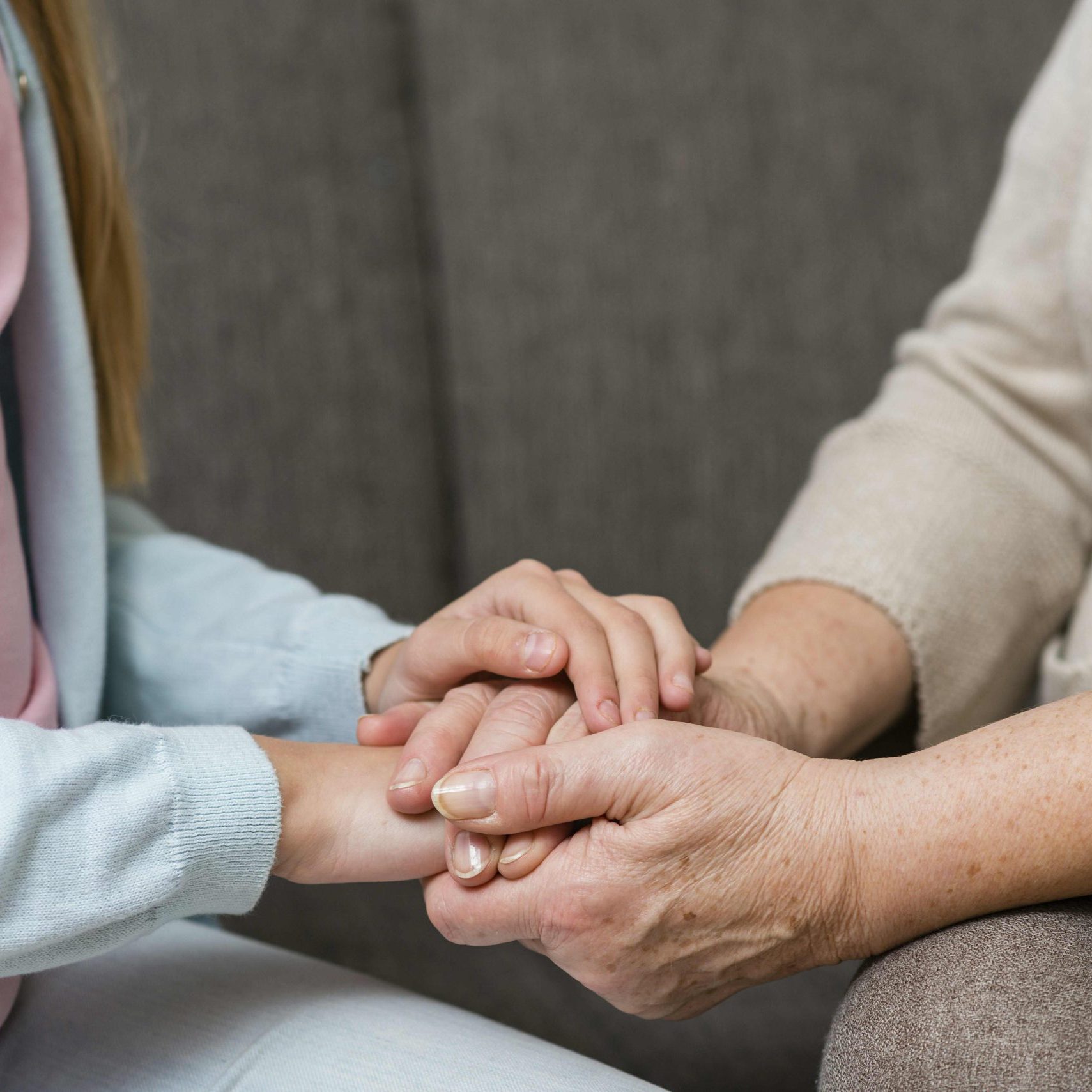 grandmother-granddaughter-holding-hands-close-up